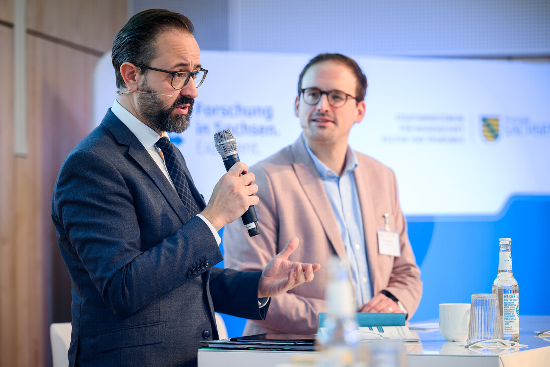 Wissenschaftsminister Sebastian Gemkow (links) mit Dr. Robert Peters, VDI/VDE Innovation + Technik GmbH, bei der Anschlusskonferenz zum Weißbuchprozess am 10. November 2023