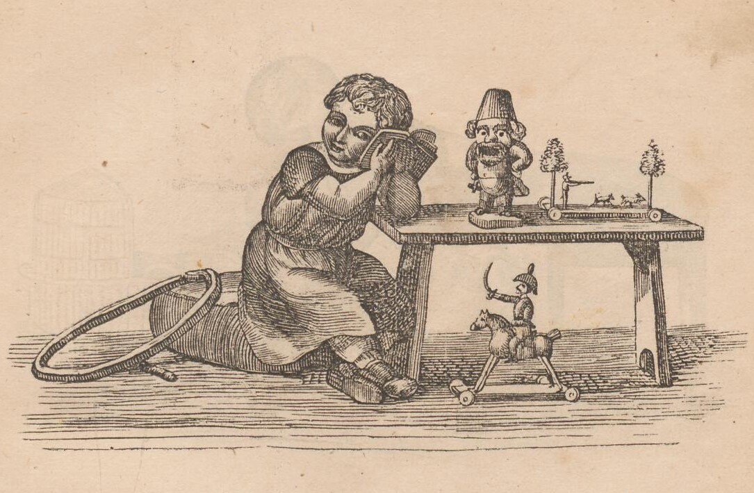 Sehr alte Illustration: Kind sitzt auf Kissen am Tisch und hält sein Ohr an ein Buch. Weiteres Spielzeug auf und unter dem Tisch und ein Reifen neben dem Kind