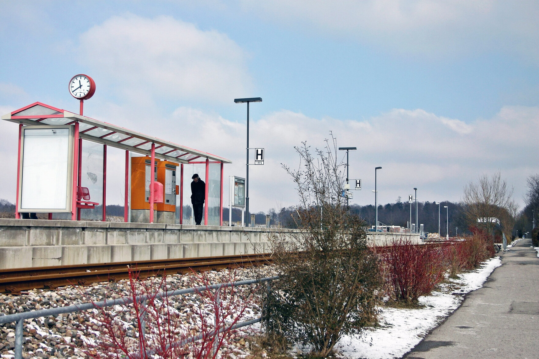 Bahngleise mit einem Wartehäuschen im außerstäditschen Raum.